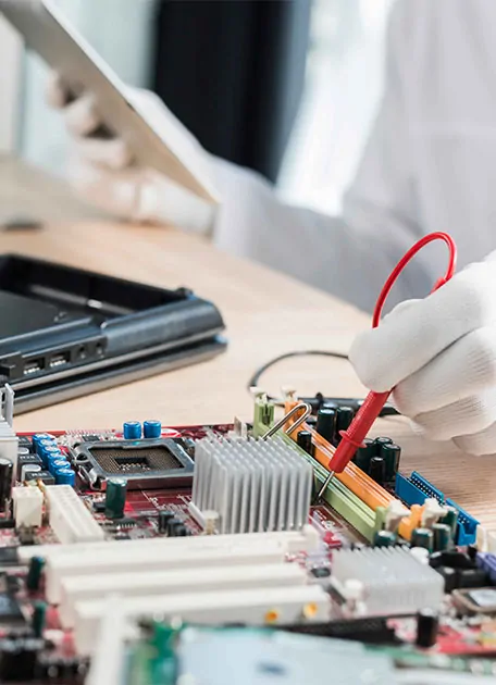 male technician examining mother board with digital multimeter